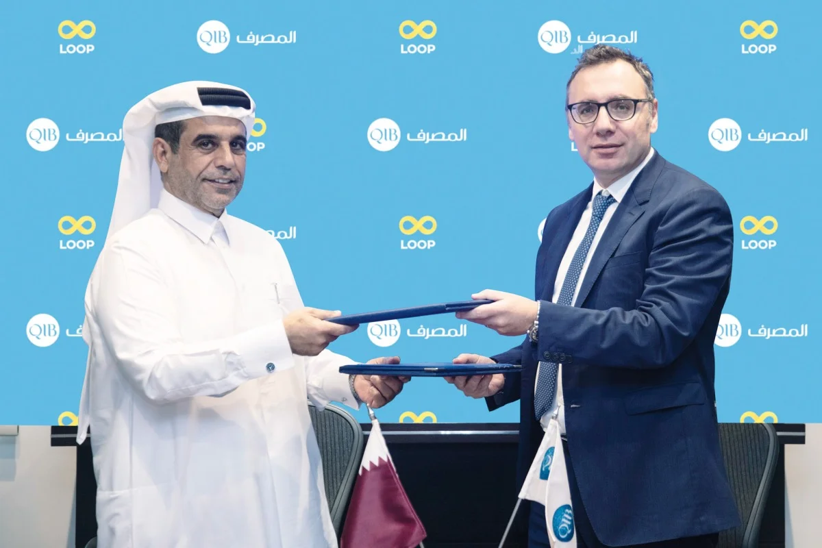 Loop and QIB representatives holding agreement folders at their September 2022 signing ceremony