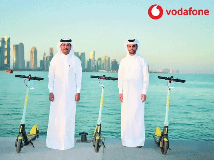 Archived photograph of two representatives beside Loop scooters on the waterfront